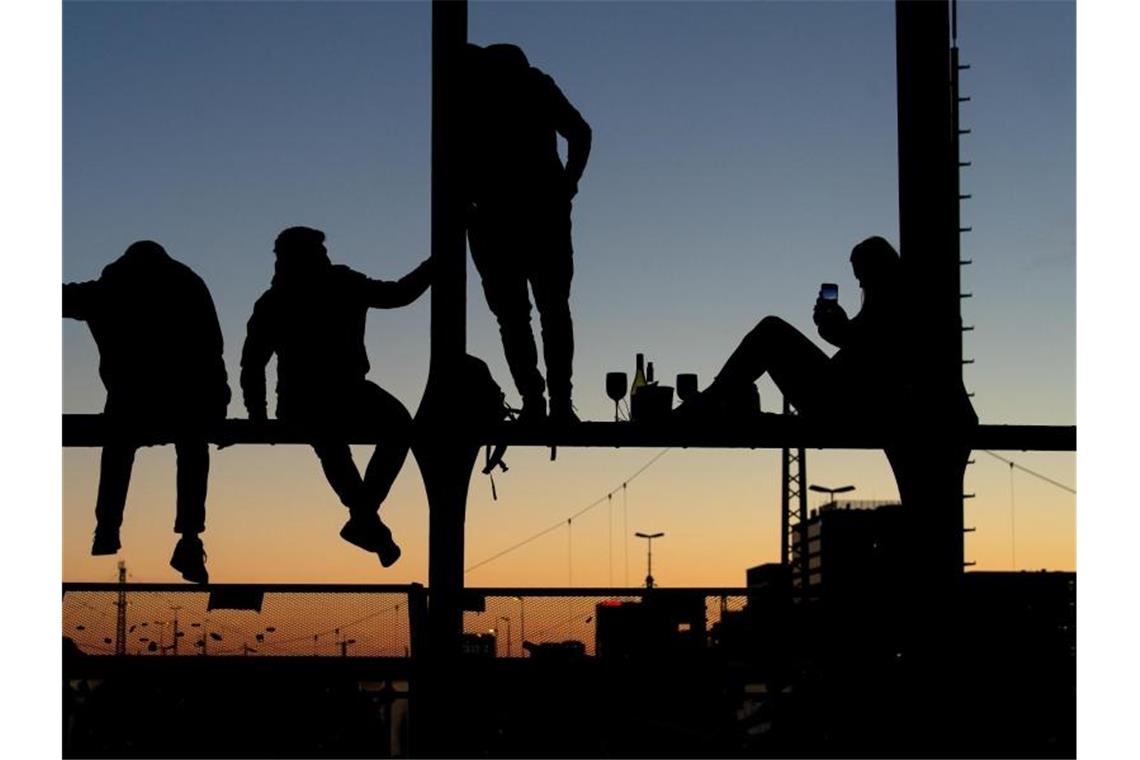 Vorsätze für 2022: Mehr Zeit für Familie und Freunde Menschen genießen den Sonnenuntergang auf der Hackerbrücke in München. Foto: Sven Hoppe/dpa