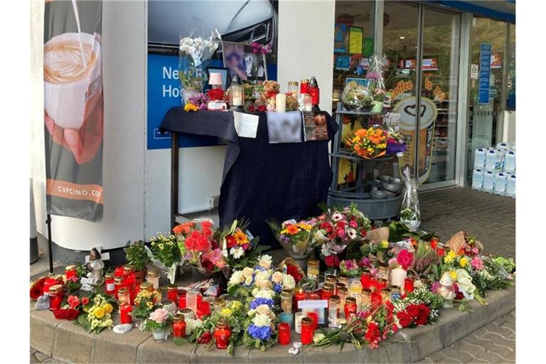 Menschen haben Blumen und Kerzen am Tatort abgelegt. Foto: Birgit Reichert/dpa
