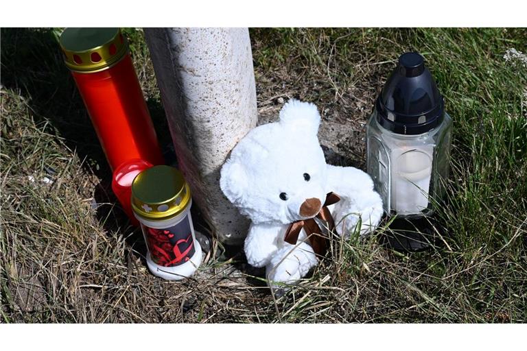 Menschen haben Kerzen und einen Teddybären an der Unfallstelle abgestellt.