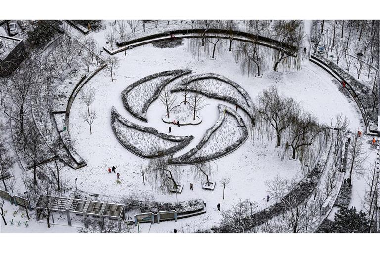 Menschen haben Spaß im Schnee in einem Park in Peking.