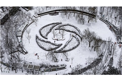 Menschen haben Spaß im Schnee in einem Park in Peking.