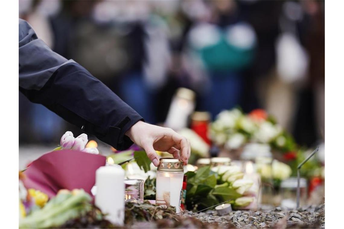 Heidelberger Amoklauf: Polizei ermittelt die Waffenverkäufer Menschen haben vor einem Gebäude der Heidelberger Universität Blumen und Kerzen niederlegt. Foto: Uwe Anspach/dpa