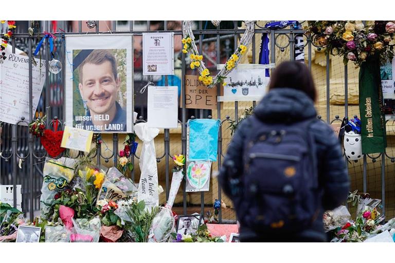 Menschen haben zum Gedenken an Rouven Laur am Tatort auf dem Mannheimer Marktplatz niedergelegt. „Bis heute werden Kerzen entzündet und Blumen gebracht“, sagt ein Arzt des nahe gelegenen Gesundheitsamts der Stadt.