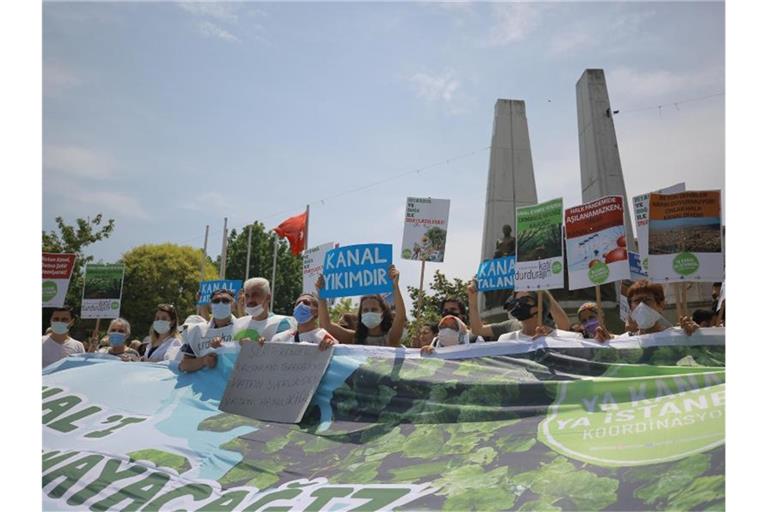 Menschen halten bei einem Protest gegen ein Kanal-Projekt des türkischen Präsidenten Erdogan Plakate und Transparente. Foto: Mucahid Yapici/AP/dpa