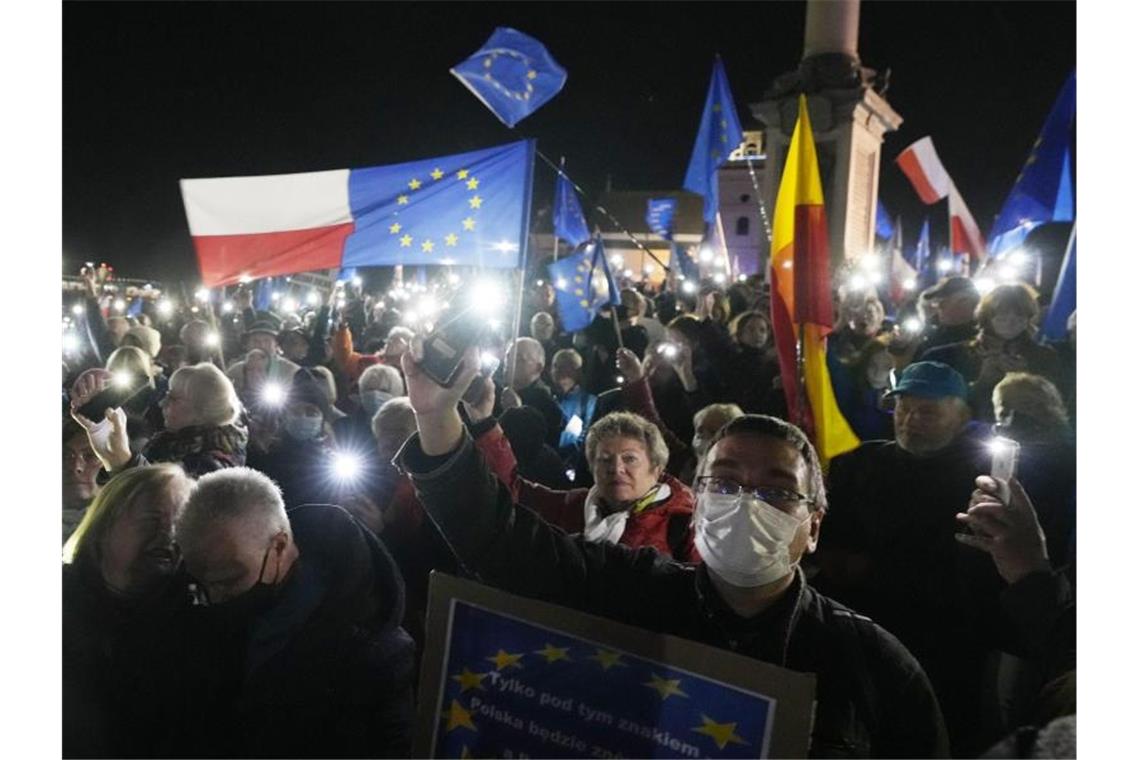 Nach Urteil des Verfassungsgerichts: Proteste in Polen Menschen halten während einer Demonstration in Warschau die Taschenlampen ihrer Mobiltelefone hoch. Foto: Czarek Sokolowski/AP/dpa