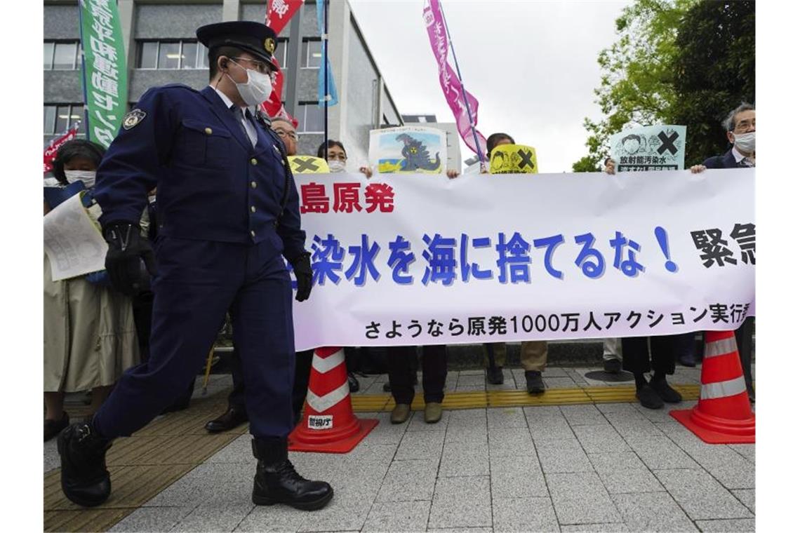 Menschen halten während einer Kundgebung vor dem Büro des Premierministers Suga ein Banner mit der Aufschrift „Werft kein radioaktives Wasser ins Meer“. Foto: Eugene Hoshiko/AP/dpa