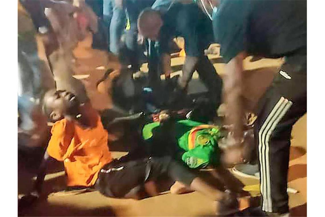 Menschen helfen den Opfern der Massenpanik vor dem Stadion in Yaoundé. Foto: Thierry Noukeu/AP/dpa