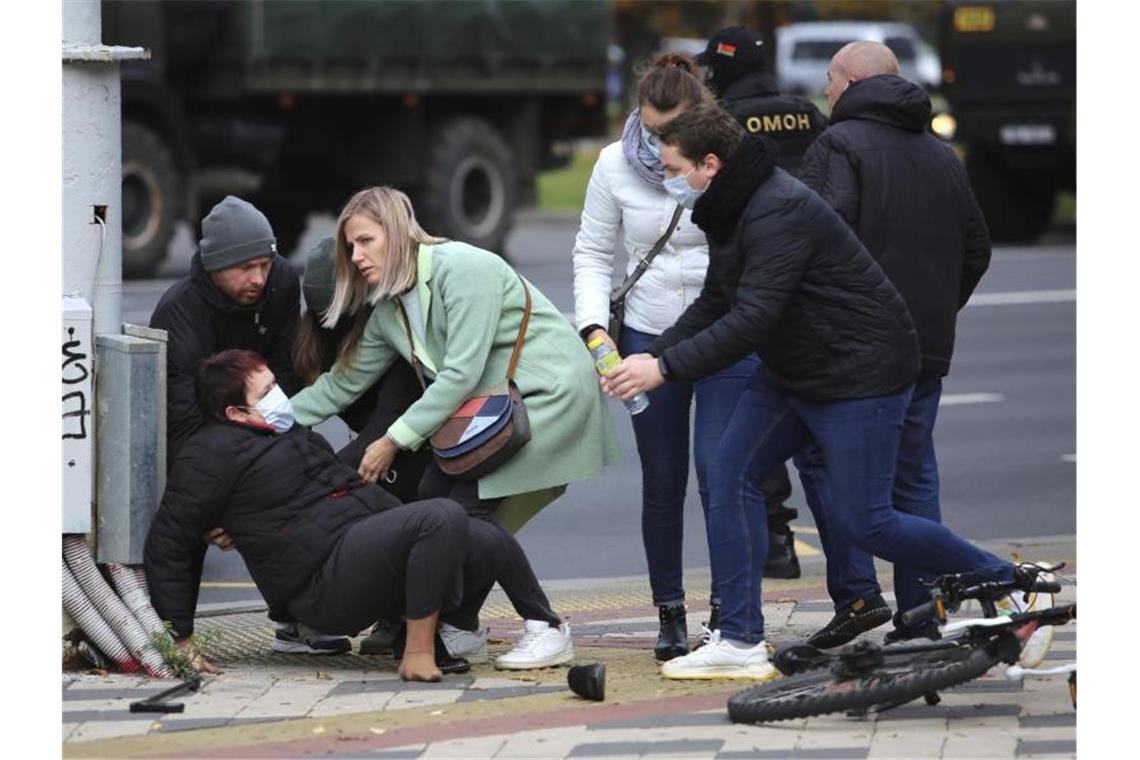 Zehntausende bei neuen Protesten gegen Lukaschenko Menschen helfen einer Frau, die während einer Kundgebung der belarussischen Opposition mit Polizisten zusammengestoßen ist. Foto: Uncredited/AP/dpa