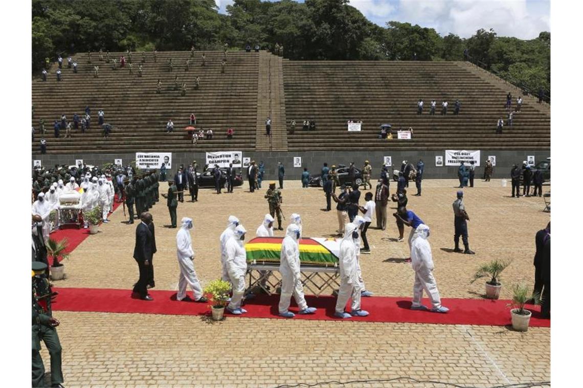 Menschen in Schutzkleidung tragen den Sarg der an Corona verstorbenen Ministerin Dr. Ellen Gwaradzimba. Seit Beginn der Pandemie sind in Simbabwe insgesamt vier Minister an Covid-19-Komplikationen gestorben. Foto: Tsvangirayi Mukwazhi/AP/dpa