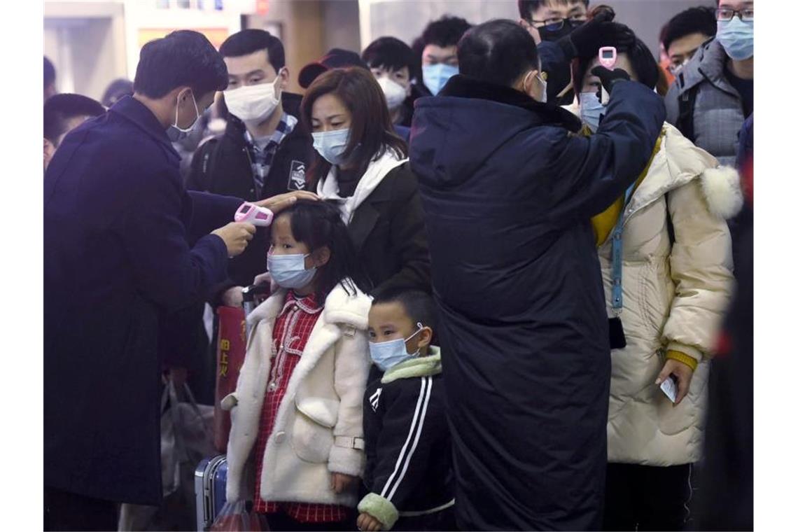 Menschen in Wuhan tragen beim Einkaufen Mundschutz-Masken. Foto: Uncredited/CHINATOPIX/AP/dpa