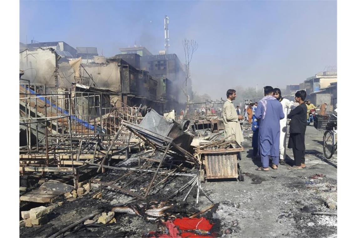 Menschen inspizieren in Kundus die Trümmer von Geschäften, die bei Kämpfen zwischen den Taliban und afghanischen Sicherheitskräften zerstört wurden. Foto: Abdullah Sahil/AP/dpa