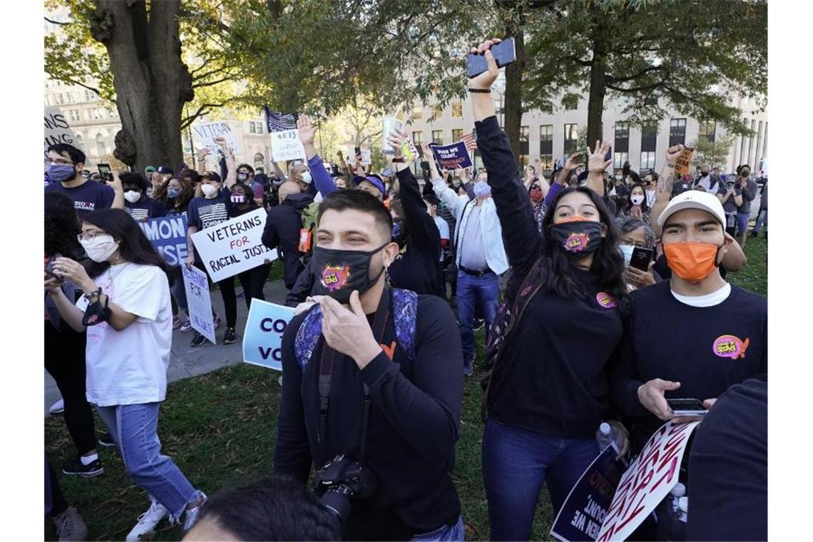 Menschen jubeln nach Bekanntgabe des Ergebnisses am Black Lives Matter Plaza in Washington. Foto: Alex Brandon/AP/dpa