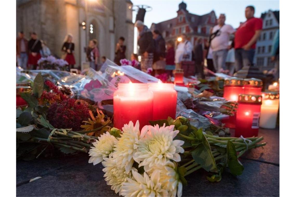 Menschen kommen nach einem ökumenischen Gedenkgottesdienst für die Opfer des Terroranschlags in Halle vor der Marktkirche in Halle (Saale) zusammen und stellen Kerzen ab. Foto: Hendrik Schmidt/dpa-Zentralbild/dpa