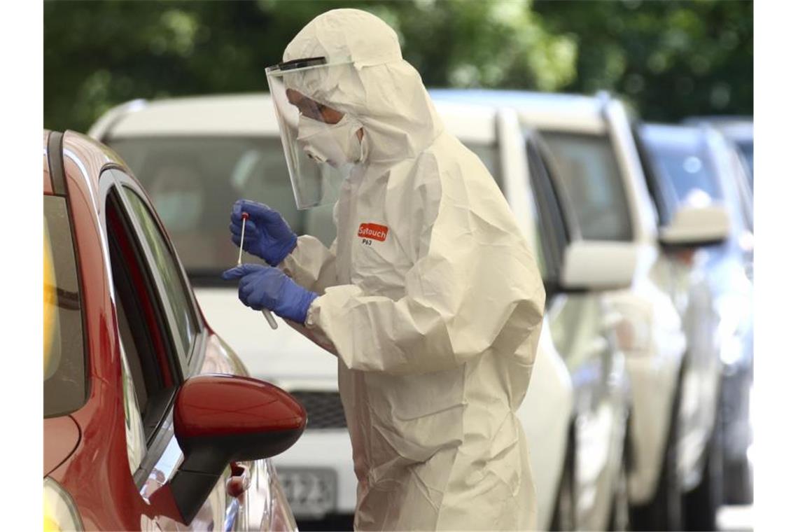 Menschen lassen sich am 28. Juli im niederbayerischen Mamming in einer behelfsmäßigen COVID-19-Teststation auf das Virus testen. Foto: Matthias Schrader/AP/dpa