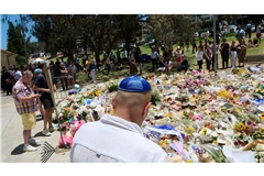 Menschen legen bei einer Gedenkfeier für die Opfer eines Terrorangriffs am Bondi Beach in Sydney Blumen nieder. (Foto aktuell)