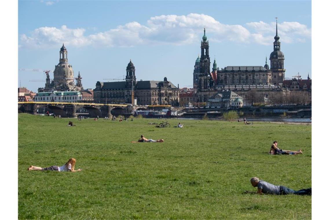 Innenminister zufrieden mit Einhaltung von Corona-Regeln Menschen liegen auf den Elbwiesen in Dresden. Foto: Robert Michael/dpa-Zentralbild/dpa