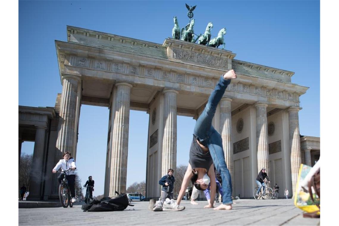 Regierung ruft zu Einhaltung der Kontaktverbote auf Menschen machen Yoga-Übungen vor dem Brandenburger Tor in Berlin. Foto: Jörg Carstensen/dpa