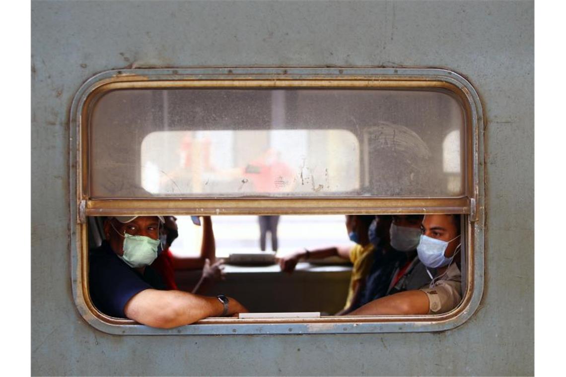 Menschen mit Gesichtsmasken sitzen in einem Zug in Kairo. Foto: Ahmed Gomaa/XinHua/dpa