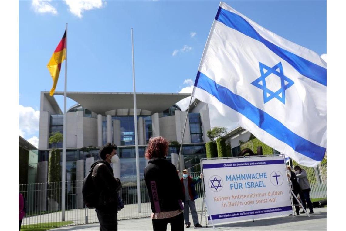 Söder: Bei Antisemitismus „mit höheren Strafen operieren“ Menschen mit israelischen Fahnen nehmen vor dem Bundeskanzleramt an einer Mahnwache für Israel teil. Die Teilnehmer wollen im Rahmen des Nahost-Konflikts auf einen Antisemitusmus in Deutschland aufmerksam machen. Foto: Wolfgang Kumm/dpa