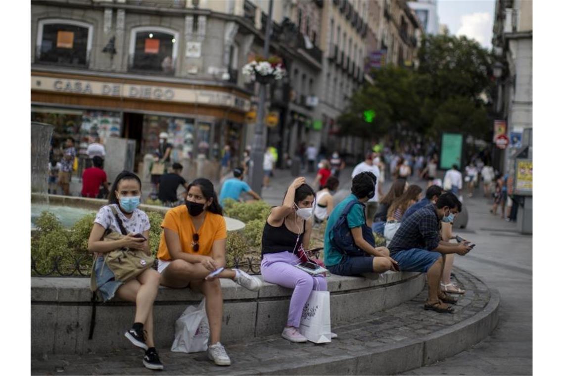 Menschen mit Masken in der Innenstadt von Madrid: Das Auswärtige Amt warnt wegen der Corona-Pandemie nun auch vor Reisen in Spaniens Hauptstadt. Foto: Manu Fernandez/AP/dpa