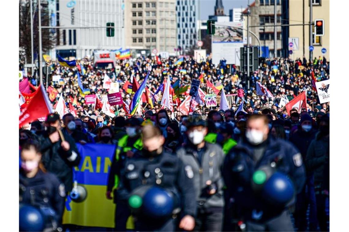 Zehntausende bundesweit bei Demos für Frieden in der Ukraine Menschen nehmen in Berlin an einer Demonstration gegen die russische Invasion in die Ukraine teil. Im Vordergrund stehen Polizisten. Foto: Fabian Sommer/dpa