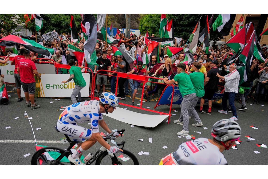 Menschen protestieren an der Strecke mit palästinensischen Fahnen gegen die Teilnahme des Radrennstalls Israel-Premier Tech an der Vuelta á España