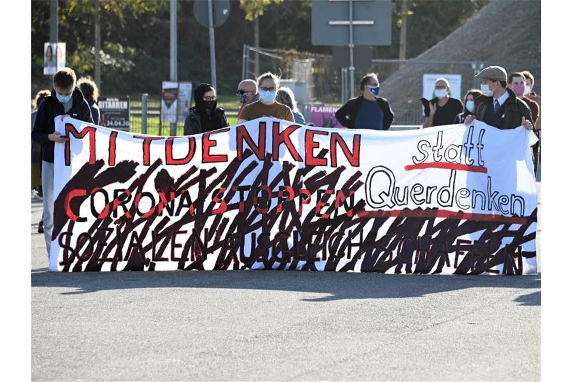 Menschen protestieren gegen die „Querdenken“-Demonstration in Karlsruhe. Foto: Uli Deck/dpa