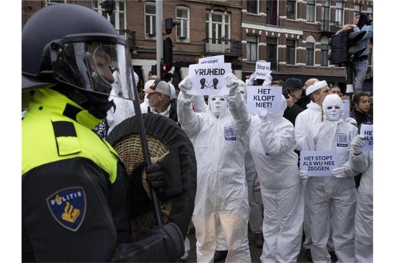 Menschen protestieren in Amsterdam bei einer verbotenen Demonstration gegen die Corona-Politik. Die Niederlande befinden sich derzeit in einem harten Lockdown, der noch bis mindestens Mitte Januar dauern soll. Foto: Peter Dejong/AP/dpa