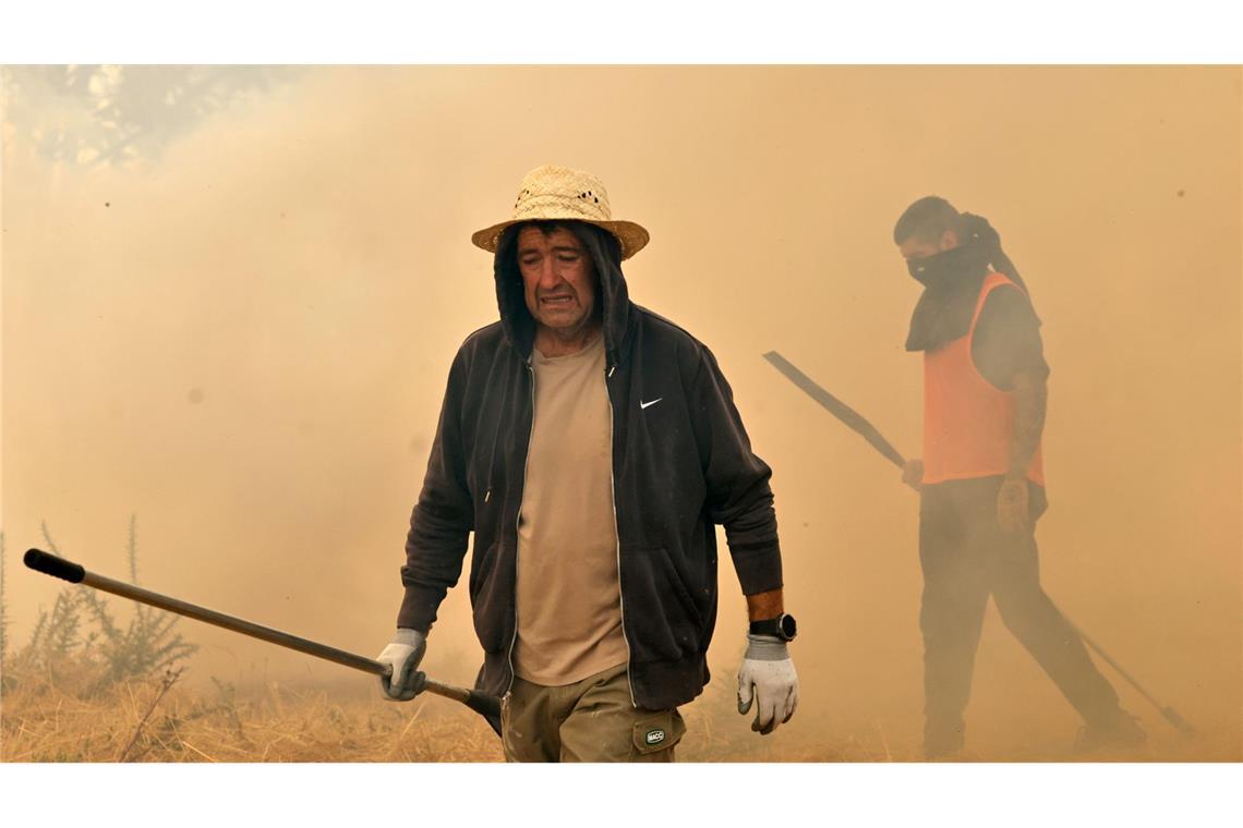 Menschen reagieren bei der Bekämpfung eines Waldbrandes in Veiga das Meas im Nordwesten Spaniens.