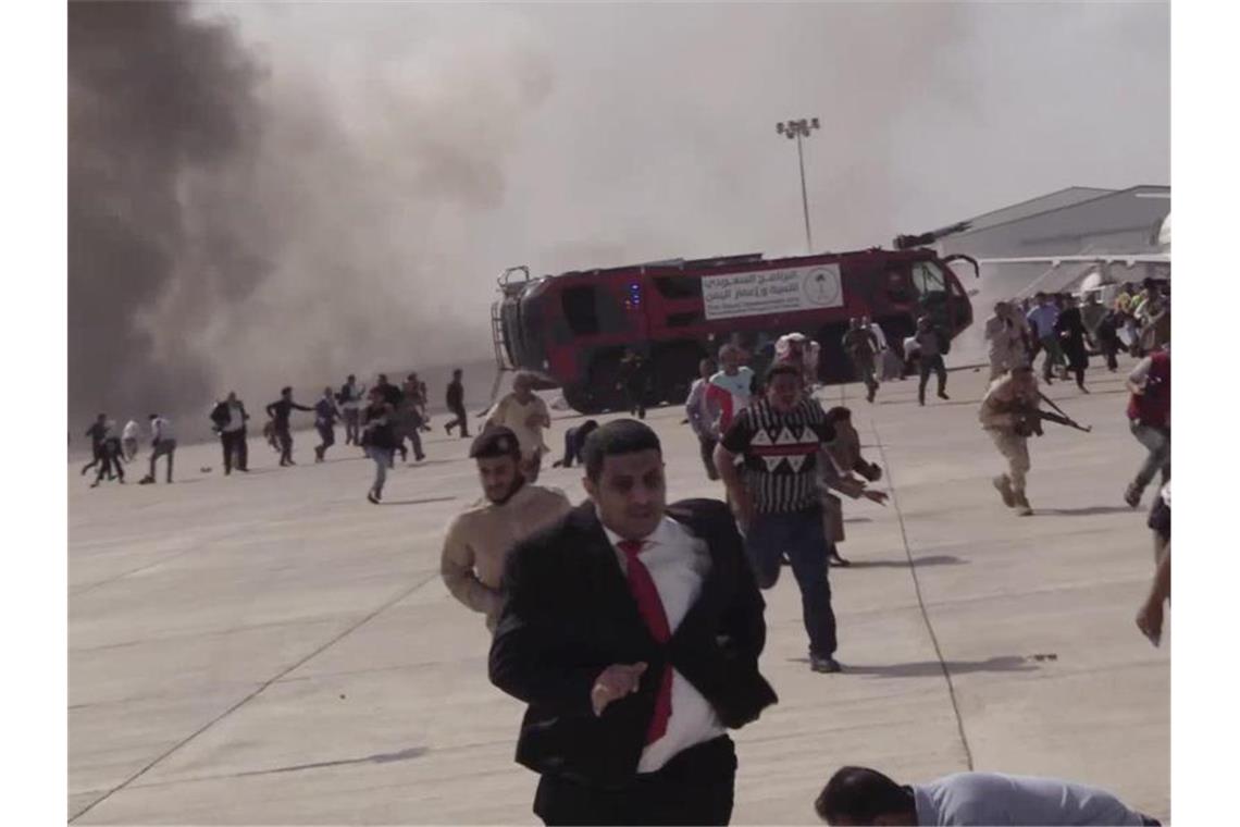 Schwere Explosion in Jemen nach Ankunft neuer Regierung Menschen rennen nach einer schweren Explosion fluchtartig über den Flughafen der jemenitischen Stadt Aden. Bei einer schweren Explosion wurden nach offiziellen Angaben mindestens 16 Menschen getötet und Dutzende verletzt. Foto: --/AP/dpa