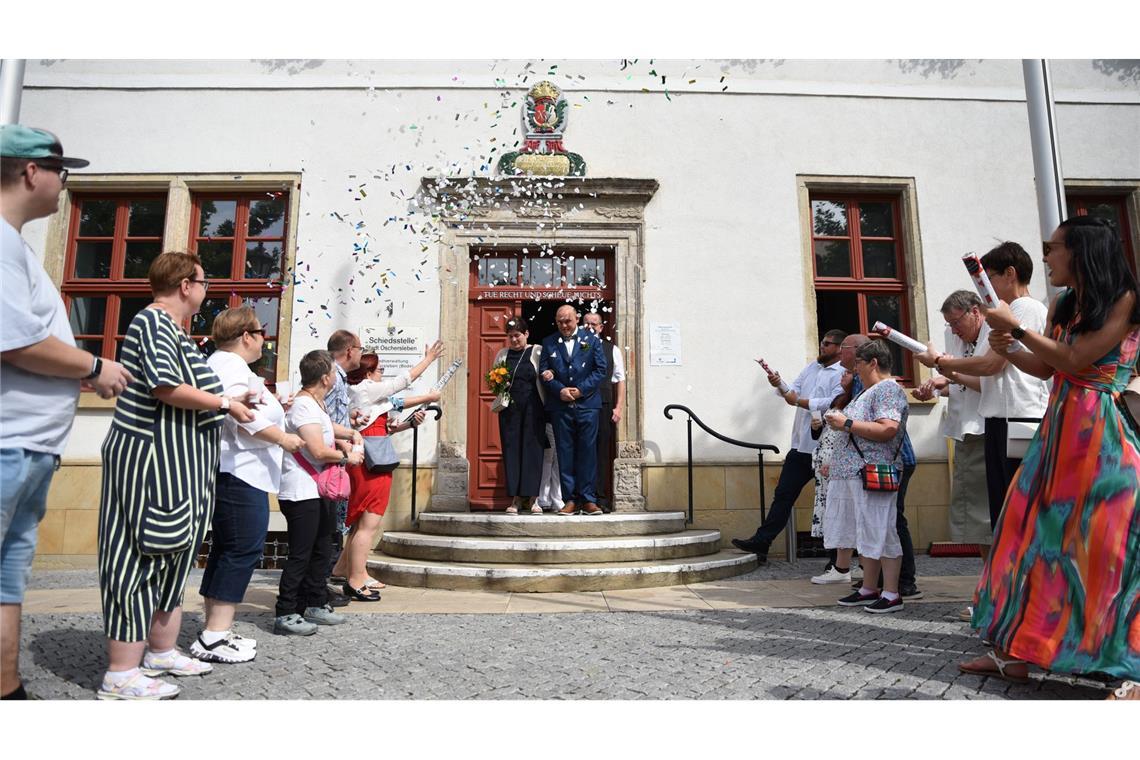 Hochzeit mit Behinderungen: 885 Tage Warten auf das Jawort Menschen schießen am Samstag (9.8.) Konfettikanonen in Richtung des Brautpaars.