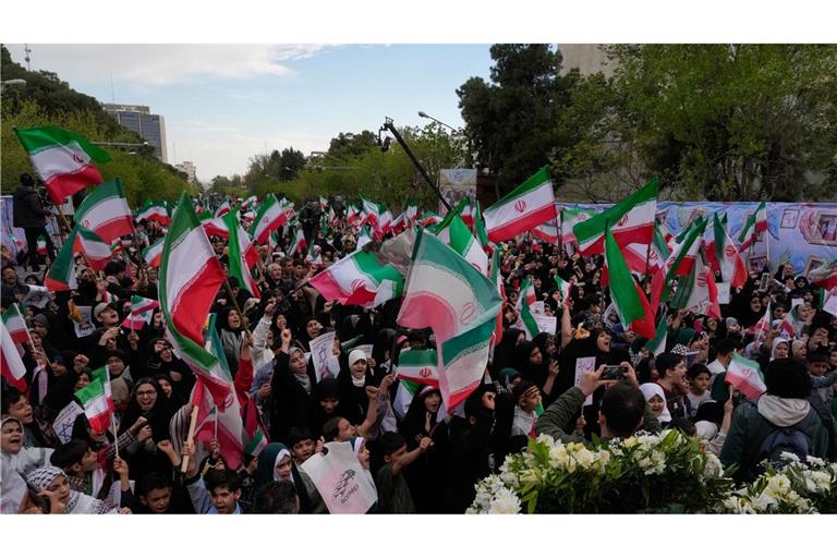 Menschen schwenken iranische Fahnen bei einer Gedenkfeier für Schulkinder, die am 28. Februar bei einem US-Luftangriff auf eine Schule in  Minab getötet wurden.