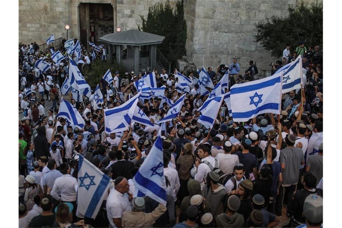 Tausende Nationalisten bei Flaggenmarsch in Jerusalem Menschen schwenken israelische Fahnen bei dem umstrittenen Flaggenmarsch in Jerusalem, der von rechtsgerichteten Nationalisten in Israel organisiert worden ist. Tausende Nationalisten zogen bei dem Marsch durch die Stadt. Foto: Ilia Yefimovich/dpa