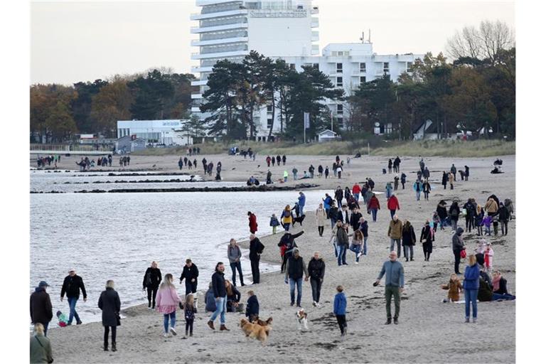 Menschen sind bei schönem Wetter während des Teil-Lockdowns an der Ostsee unterwegs. Foto: Bodo Marks/dpa