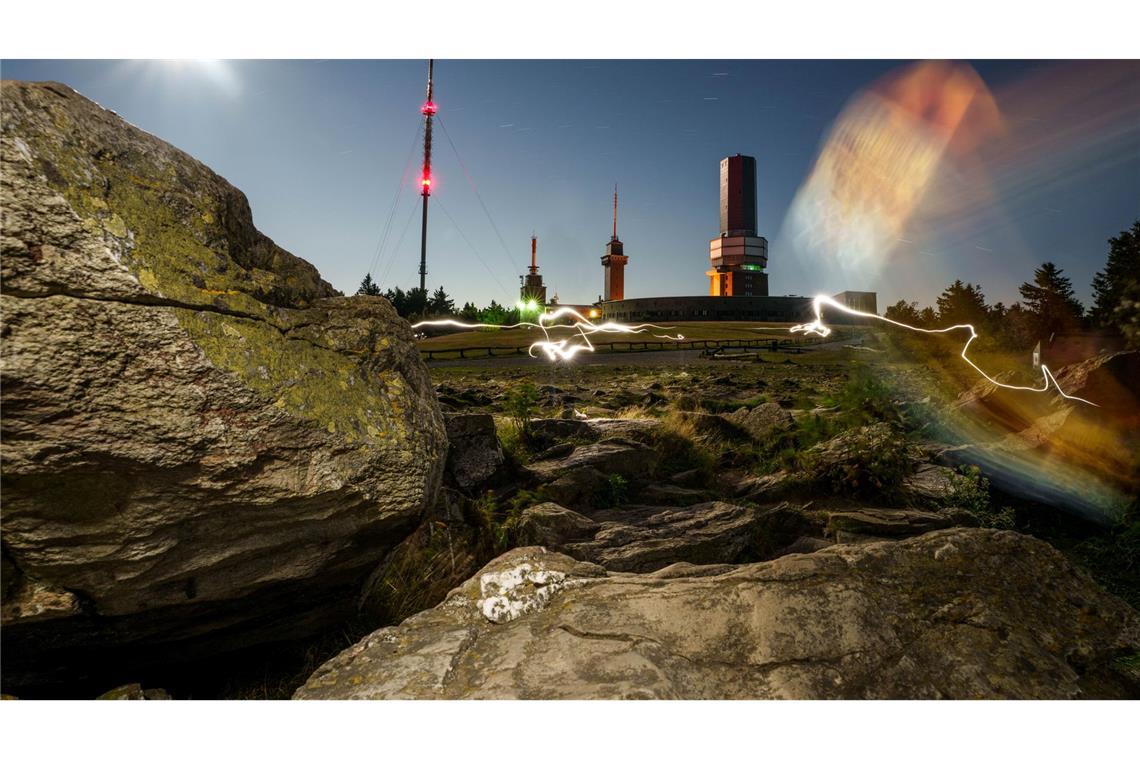 Menschen sind um Mitternacht mit Taschenlampen auf dem Feldberg-Plateau unterwegs und hinterlassen bei der Langzeitbelichtung Lichtreflexe. Der Ansturm auf den Hausberg im Rhein-Main-Gebiet wird in der Nacht von Dienstag auf Mittwoch (12. auf 13. August) vermutlich sehr groß sein. Der Sternschnuppen-Strom der Perseiden über Deutschland wird seinen Höhepunkt erreichen und lässt sich von der höchsten Erhebung im Taunus gut beobachten.