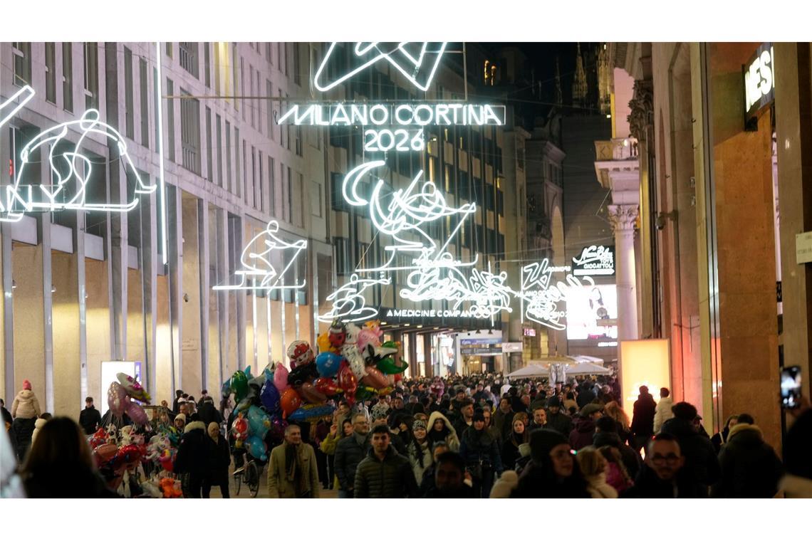 Menschen spazieren durch das Stadtzentrum Mailands, welches mit Beleuchtung für die bevorstehenden Olympischen Winterspiele in Italien 2026 geschmückt ist.
