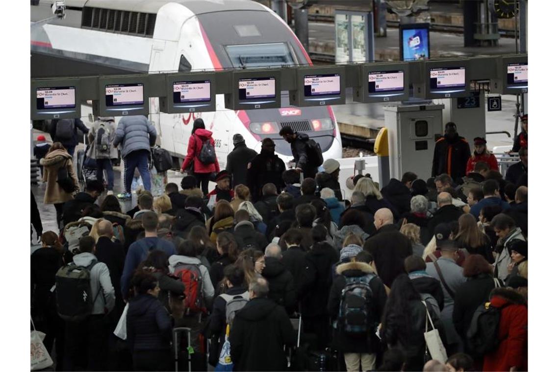 Menschen stehen am Bahnhof „Gare de Lyon“ in Paris an, um in einen Zug zu steigen. Foto: Christophe Ena/AP/dpa