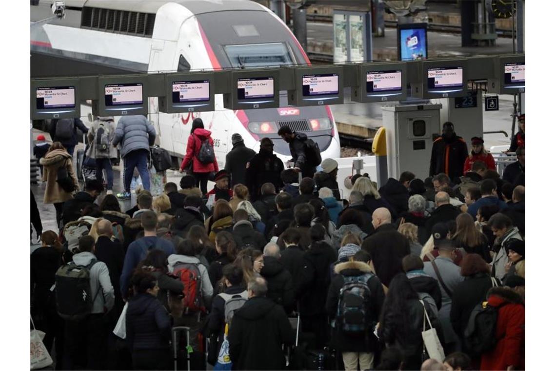Bahnchaos lähmt Vorweihnachtsverkehr in Frankreich Menschen stehen am Bahnhof „Gare de Lyon“ in Paris an, um in einen Zug zu steigen. Foto: Christophe Ena/AP/dpa
