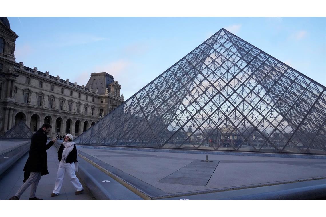 Menschen stehen an der Pyramide des Louvre-Museums am Montagmorgen.