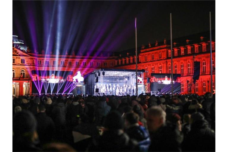 Menschen stehen an Silvester auf dem Schlossplatz in Stuttgart. Foto: Christoph Schmidt/dpa