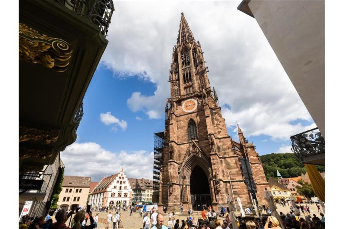 Freiburg weltweit unter Top Drei bei „Lonely Planet“-Tipps Menschen stehen auf dem Freiburger Münsterplatz vor dem Münster. Foto: Philipp von Ditfurth/dpa