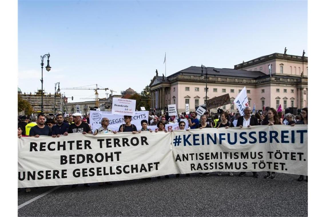 Menschen stehen bei der „Unteilbar“-Demonstration gegen Antisemitismus mit einem Transparent auf dem Bebelplatz in Berlin. Foto: Paul Zinken/dpa