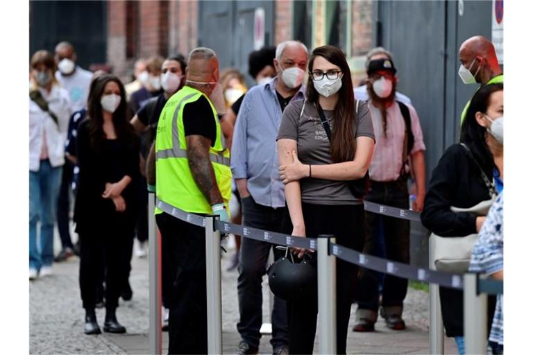 Menschen stehen beim Impfzentrum in Berlin-Treptow an. Im weiteren Kampf gegen die Corona-Pandemie will der Bundestag noch kurz vor der Wahl einige Neuregelungen beschließen. Foto: John Macdougall/AFP POOL/dpa