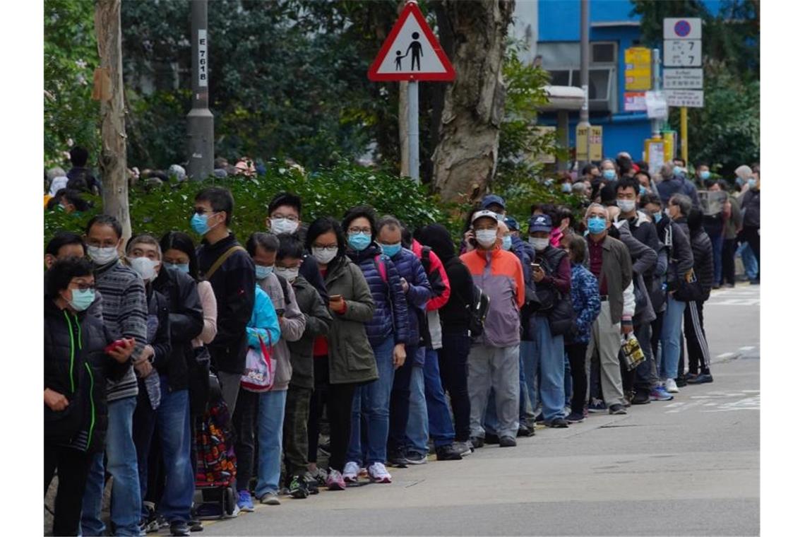 Coronavirus: Entwarnung für Deutsche auf Schiff Menschen stehen in Hongkong an, um Schutzmasken zu kaufen. Foto: Vincent Yu/AP/dpa