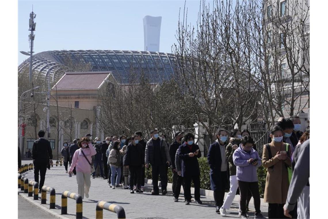 Corona-Infektionszahlen in China steigen weiter Menschen stehen in Peking Schlange für einen Corona-Test. Foto: Ng Han Guan/AP/dpa