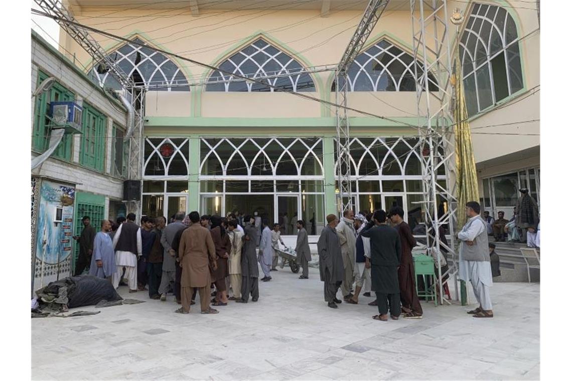 Menschen stehen nach der Explosion in einer Moschee zusammen. Foto: Sidiqullah Khan/AP/dpa