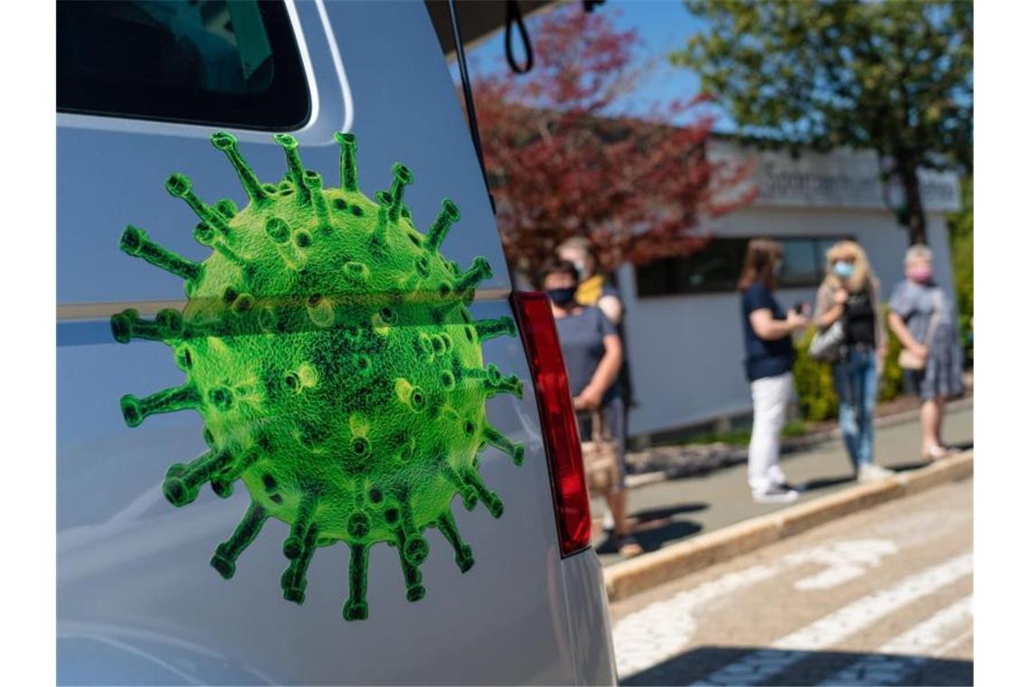 Menschen stehen Schlange, um sich bei einer mobilen Corona-Teststation im bayerischen Rehau auf das Virus testen zu lassen. Foto: Nicolas Armer/dpa