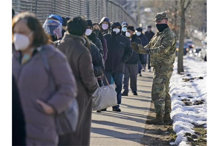 Menschen stehen vor einem Impfzentrum im New Yorker Stadtteil Queens Schlange. Foto: Seth Wenig/AP/dpa
