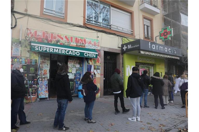 Menschen stehen vor einer Apotheke in Madrid an, um einen Schnelltest zu kaufen. Foto: Isabel Infantes/EUROPA PRESS/dpa