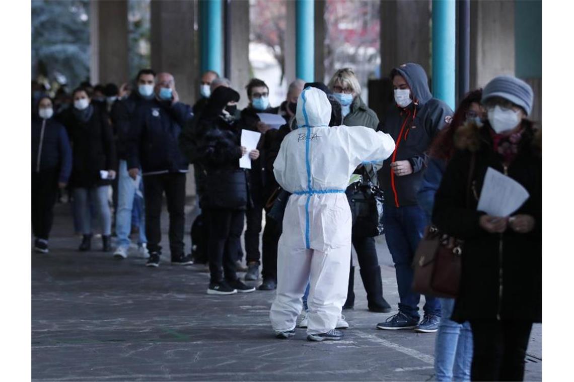 Menschen stehen vor einer Corona-Schnelltest-Einrichtung in Bozen (Südtirol) Schlange. Foto: Antonio Calanni/AP/dpa